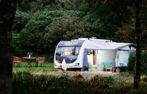 a blue and white van with a tent in a field at Pinetum Garden Retreats in St Austell