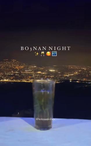 a glass sitting on top of a table with a city at joli appart avec terrasse au centre ville in Tetouan