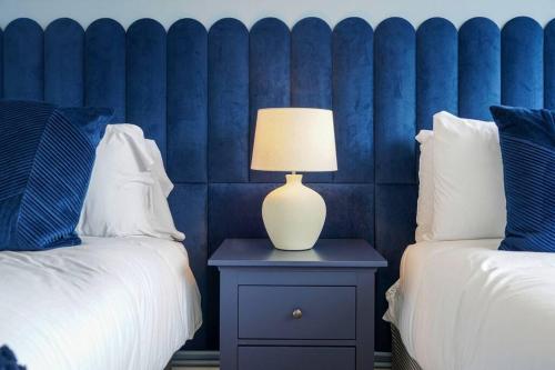 a bedroom with two beds and a lamp on a nightstand at Stunning 2 Bedroom Apartment - Close to City Centre - Free Parking, Super-fast WIFI, SmartTV, Private Balcony and Communal Garden by Yoko Property in Coventry