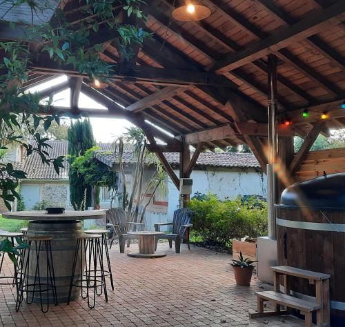 a patio with a wooden pergola and tables and chairs at Gite le Trouilh in Saint-Maurice-sur-Adour