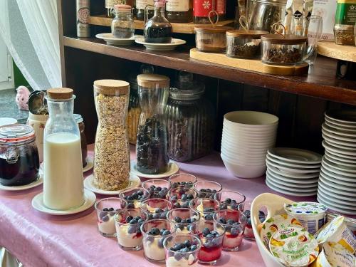 a table topped with dishes and jars of food at Villa Antica in Kudowa-Zdrój