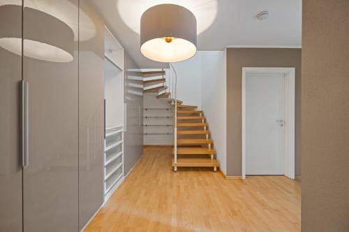 a staircase in a room with white walls and wooden floors at 3 Zimmer EG Wohnung in Stephanskirchen in Stephanskirchen