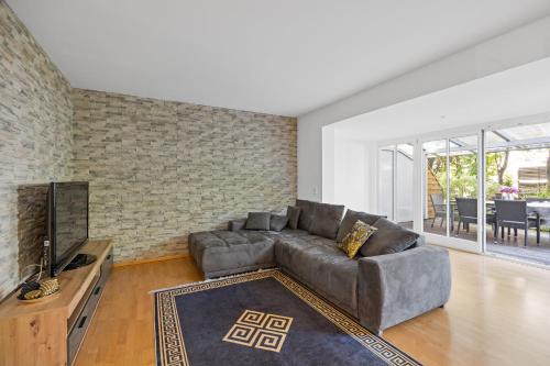 a living room with a couch and a tv at 3 Zimmer EG Wohnung in Stephanskirchen in Stephanskirchen