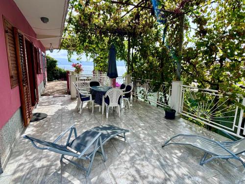 a patio with a table and chairs on a patio at Podaca house in Podaca