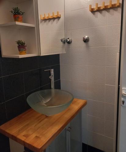 a bathroom with a glass bowl sink on a wooden counter at uRban Loft Living in Kardítsa