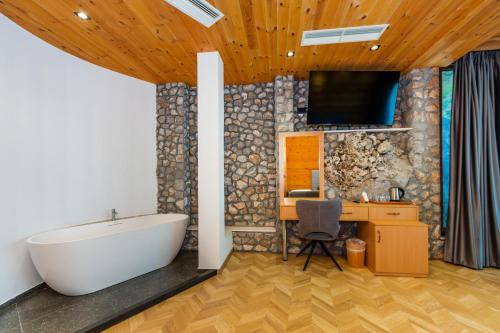 CanajにあるNature Houseのバスルーム(バスタブ付)、デスク、テレビが備わります。