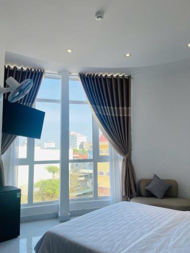a bedroom with a bed and a large window at KHÁCH SẠN ROMO in Quang Ngai