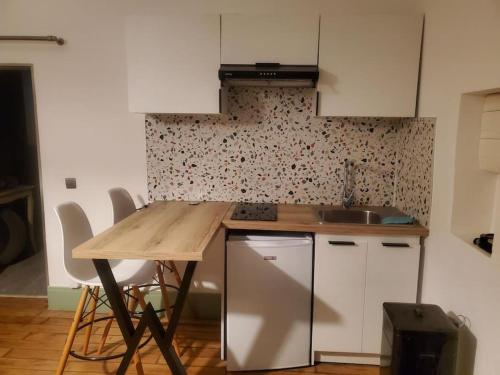 une cuisine avec un comptoir en bois et un évier dans l'établissement Le courpata, à Bougé-Chambalud