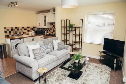 a living room with a couch and a television at Large Apartments next to East Midlands Airport with Free Gated Parking! in Castle Donington