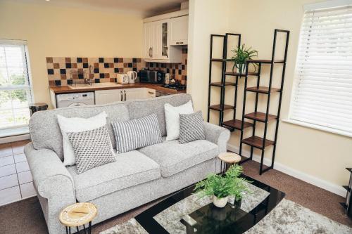 a living room with a couch and a kitchen at Large Apartments next to East Midlands Airport with Free Gated Parking! in Castle Donington