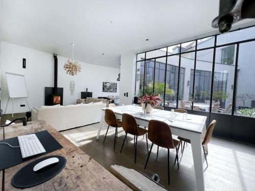 une table blanche et des chaises dans un salon dans l'établissement Villa cosy Paris, à La Garenne-Colombes