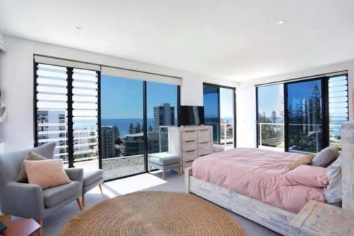 a bedroom with a bed and a large window at Living The Dream Penthouse in Tweed Heads