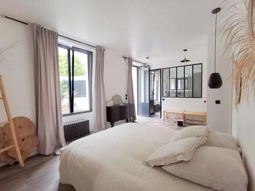 Un dormitorio con una cama grande y una ventana grande. en Villa cosy Paris, en La Garenne-Colombes