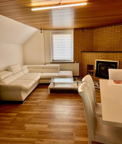 un soggiorno con divano e camino di Messe Apartment in Laatzen mit kostenlosen Parkplätz ad Hannover