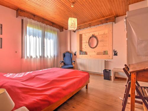 - une chambre avec un lit rouge et un bureau dans l'établissement Chalet spacieux à quelques pas du centre et des pistes de Morzine, avec cheminée et terrasse. - FR-1-524-18, à Morzine