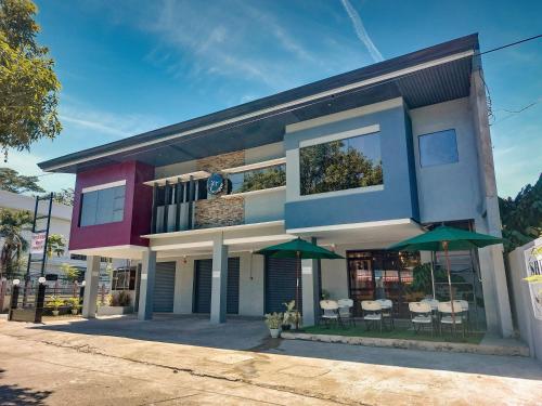 a building with green umbrellas in front of it at Jczar Suites in Gingoog