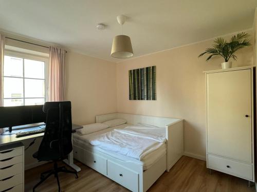 a bedroom with a bed and a desk with a computer at Private Apartment & rooms near fairground Hannover in Hannover