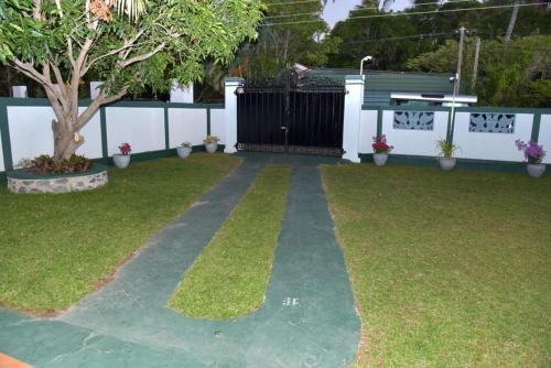 a garden with a bench and grass and a fence at Sri Ra'anana Villa in Marawila