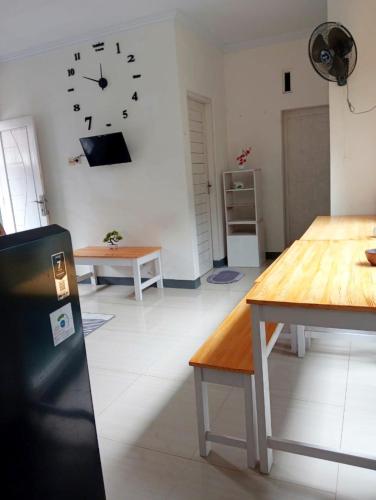 a room with a table and a clock on the wall at NEVA Homestay in Ngingas