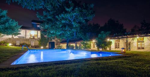 a swimming pool in a yard at night at Quinta da Bemposta in Joane