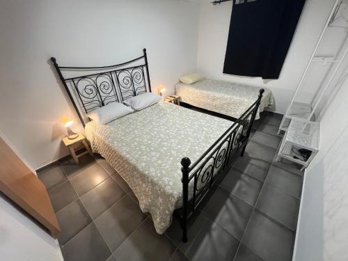 two beds in a small room with two lamps at ESTANQUEIRA GUEST HOUSE in Sines