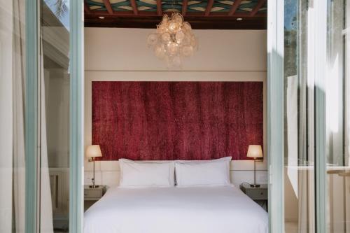 a bedroom with a white bed and a chandelier at Les Deux Tours in Marrakech
