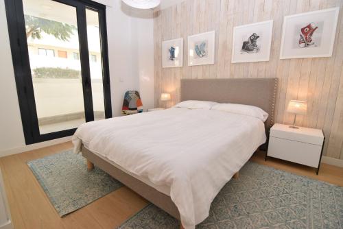a bedroom with a large white bed and a window at Dream Gardens 2 in Mijas Costa
