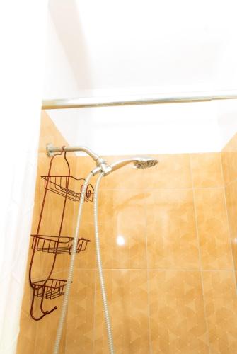 a shower in a bathroom with a shower head at One more night in Ocho Rios