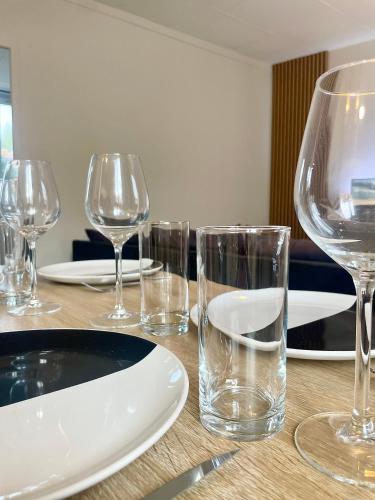 - une table en bois avec des verres à vin et des assiettes dans l'établissement Sologne évasion, à La Ferté-Saint-Aubin
