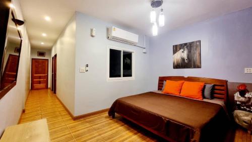 a bedroom with a bed with orange pillows on it at Baan Bua Talay in Ko Samed