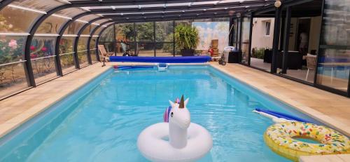 a swimming pool with a inflatable unicorn in the water at Fare-Kermenezy maison avec piscine chauffée in Locmaria-Grand-Champ