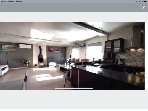 a large kitchen and living room with a couch and a table at Maison loft, jacuzzi in Livry-Gargan