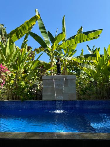 a fountain in the middle of a pool at Private Villa Kayu Padangbai in Padangbai