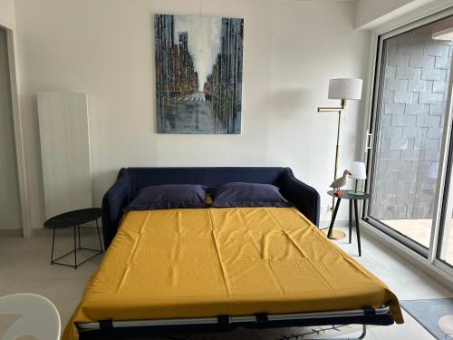 1 dormitorio con 1 cama con sábana amarilla en Corniche - Petite Vue Mer - Terrasse - Parking Privé - Bénodet, en Bénodet