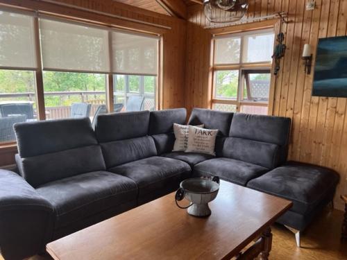 a living room with a black couch and a table at Cabin in Vaðnes in Selfoss