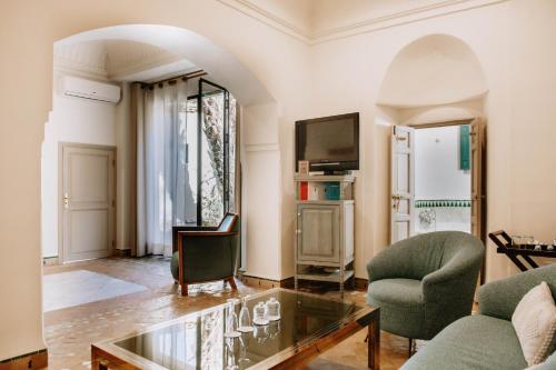 a living room with a glass table and two chairs at Les Deux Tours in Marrakech