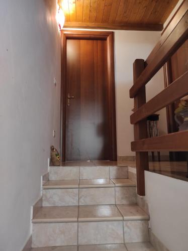 a hallway with a wooden door and some stairs at Green House in Rocca di Botte