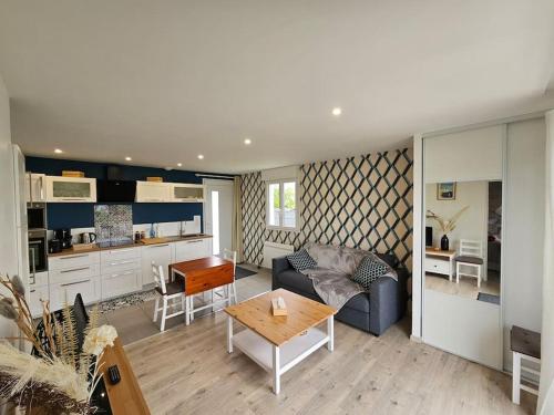 un salon avec un canapé et une table dans l'établissement Charmante maison proche Etretat Chez Fleurette, au Tilleul