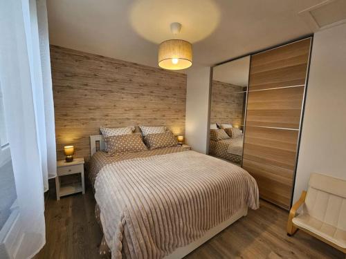 une chambre avec un grand lit et un miroir dans l'établissement Charmante maison proche Etretat Chez Fleurette, au Tilleul