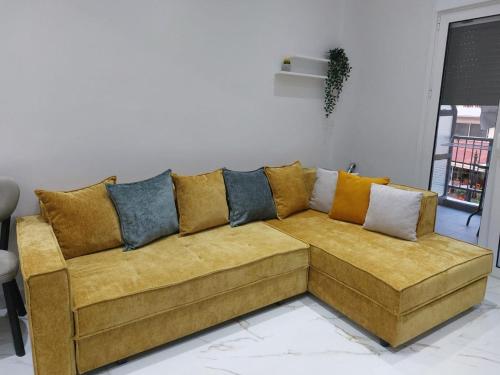 a couch with many pillows on it in a living room at Loutraki comfortable apartment center 50m from the sea in Loutraki