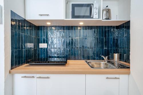 une cuisine avec un évier et un micro-ondes dans l'établissement Studio hypercentre de Nice climatisé, à Nice