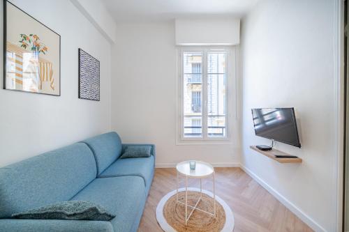 un salon avec un canapé bleu et une télévision dans l'établissement Studio hypercentre de Nice climatisé, à Nice