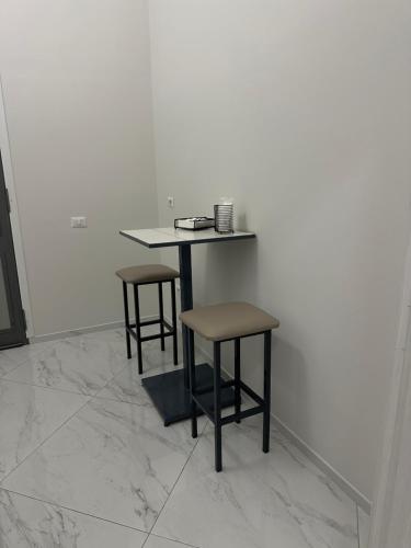 a table and two stools in a room at Vi Luxury Room in Pagani