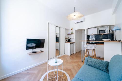 un salon avec un canapé bleu et une table dans l'établissement Studio hypercentre de Nice climatisé, à Nice
