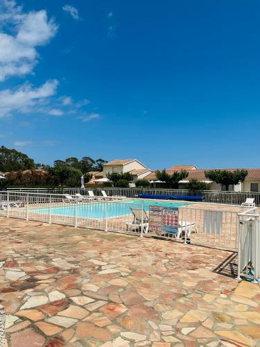 une piscine avec deux chaises et une clôture dans l'établissement Mini villa piscine et plage, à Cervione