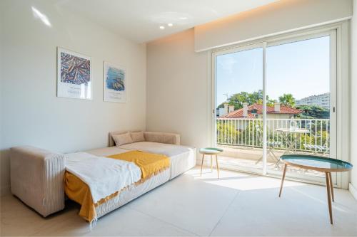 une chambre avec un lit et une grande fenêtre dans l'établissement Parc Borély, Balcon & Résidence de Standing, à Marseille