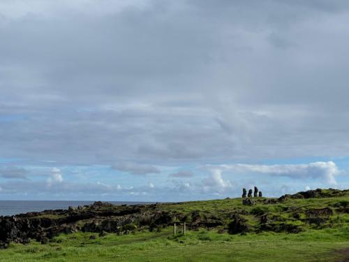 a group of people standing on a hill near the ocean at Cabañas Anavai Rapa Nui in Hanga Roa