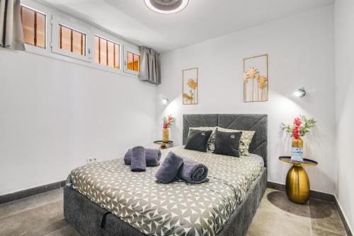 a bedroom with a bed with blue pillows on it at Patalavaca Beach, One Bedroom Apartment in Patalavaca
