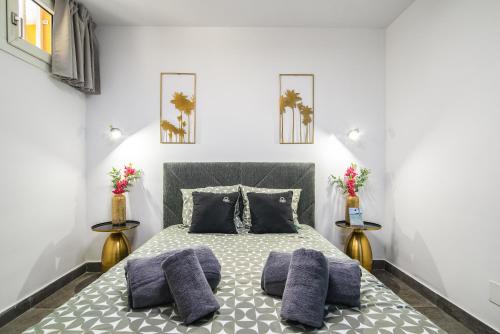 a bedroom with a large bed with purple pillows at Patalavaca Beach, One Bedroom Apartment in Patalavaca