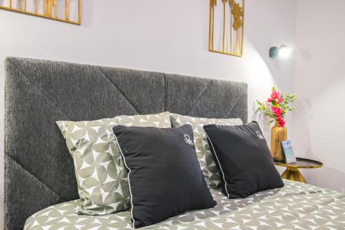 a bed with two pillows and a gray headboard at Patalavaca Beach, One Bedroom Apartment in Patalavaca